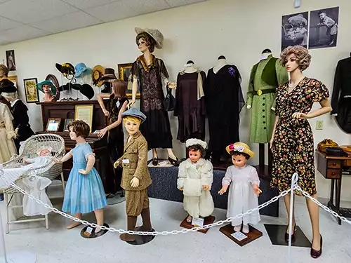 Women and children mannequins in 20th century fashions