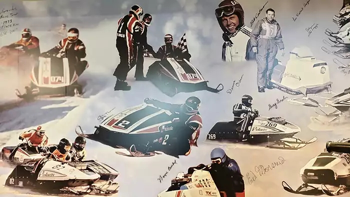 Photos of a dozen Polaris race snowmobiles with their drivers. 