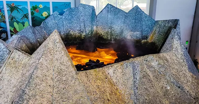 Volcano shaped model with lava and lava rock inside. 