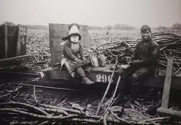A woman and man taking a break in a sugr can field.