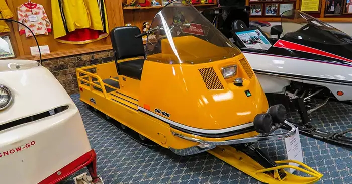 Focal point is a yellow Ski-Doo snowmobile. 