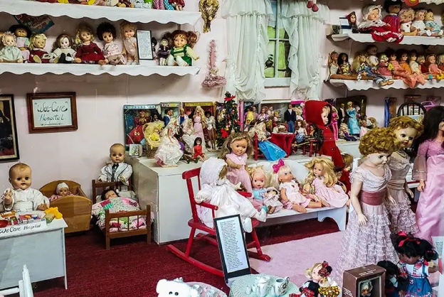 Doll collection on shelves and benches.